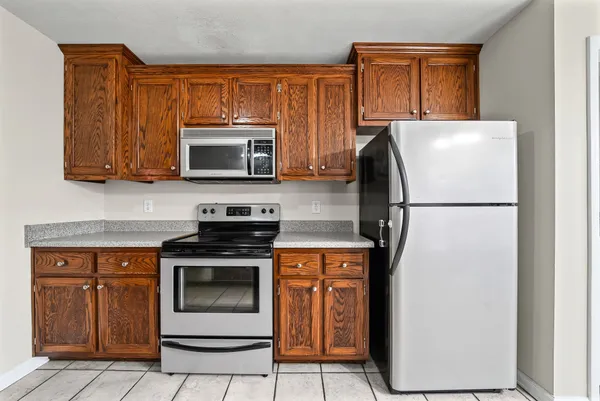 a kitchen with a stove a microwave and a refrigerator