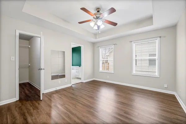 a view of an empty room with window and wooden floor