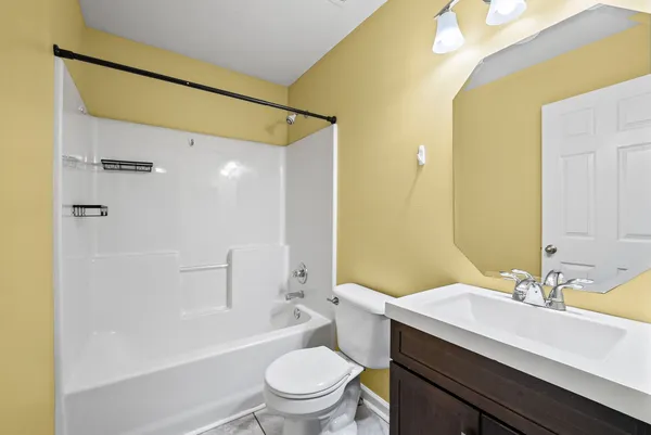 a bathroom with a sink a toilet a mirror a bathtub and shower