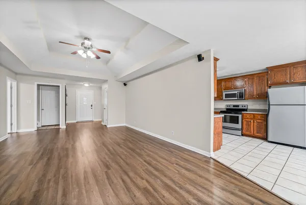 a view of a kitchen with refrigerator and wooden floor