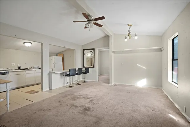 a view of a livingroom with a furniture a ceiling fan and window