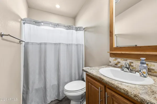 a bathroom with a granite countertop sink toilet and shower