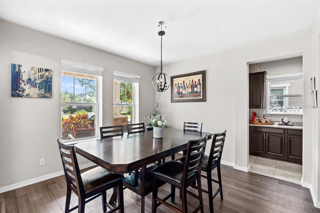 5955 Caldera Ridge Drive Lithia, FL 33547 - Photo 29 of 71 a dining room with furniture a chandelier and wooden floor