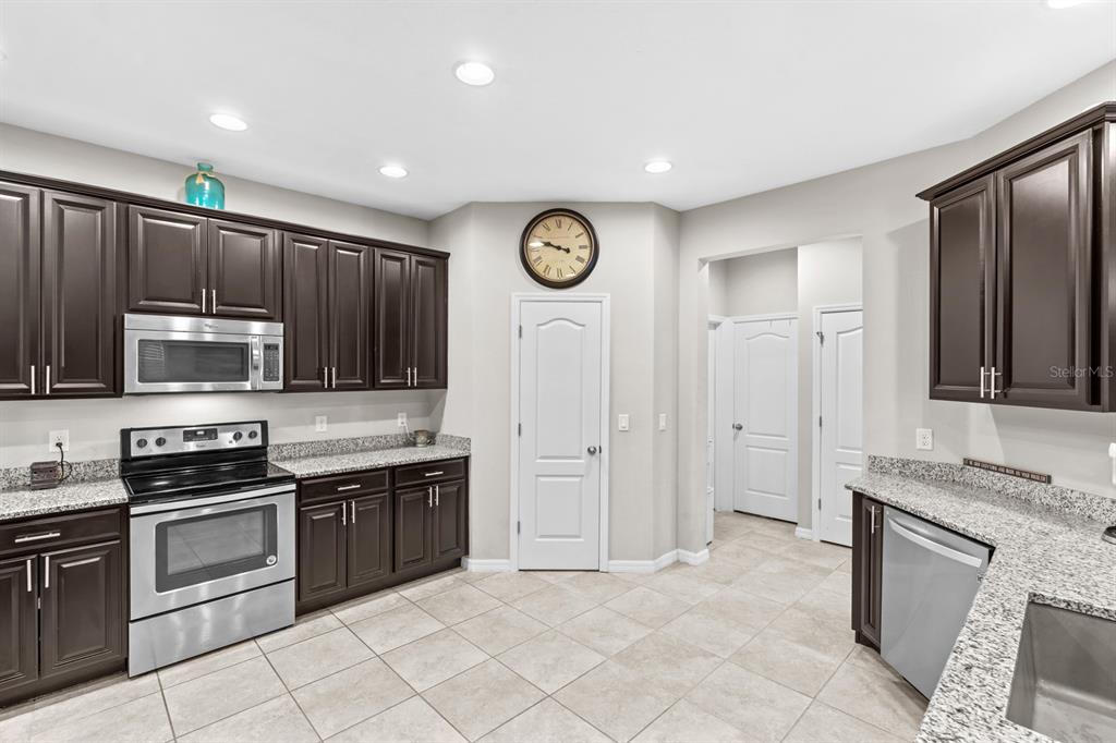 5955 Caldera Ridge Drive Lithia, FL 33547 - Photo 34 of 71 a kitchen with stainless steel appliances granite countertop a stove top oven a sink and dishwasher