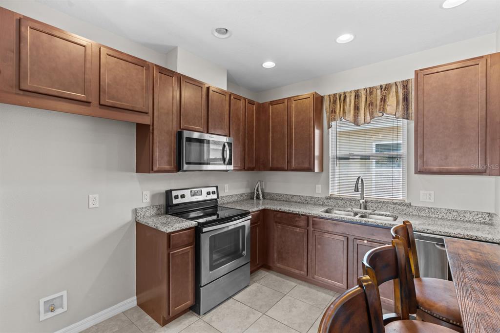 5955 Caldera Ridge Drive Lithia, FL 33547 - Photo 66 of 71 a kitchen with stainless steel appliances granite countertop a sink stove and microwave