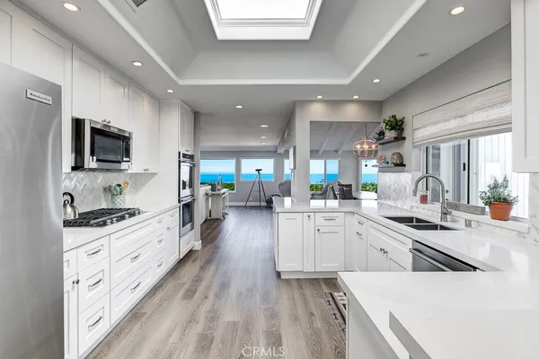 a large kitchen with stainless steel appliances lots of counter space and wooden floor