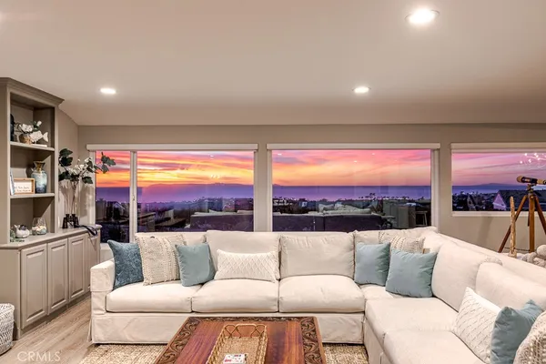 a living room with furniture a floor to ceiling window and a flat screen tv