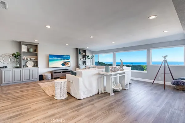 a living room with furniture a flat screen tv and a wooden floor
