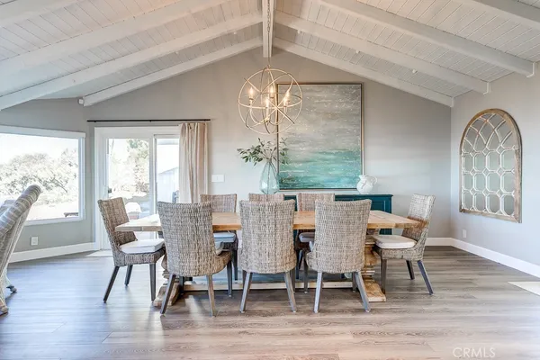 a dining room with furniture a chandelier and wooden floor