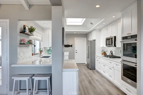 a large kitchen with kitchen island a large counter top space appliances and cabinets