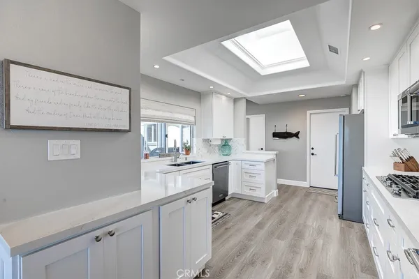 a kitchen with white cabinets and window