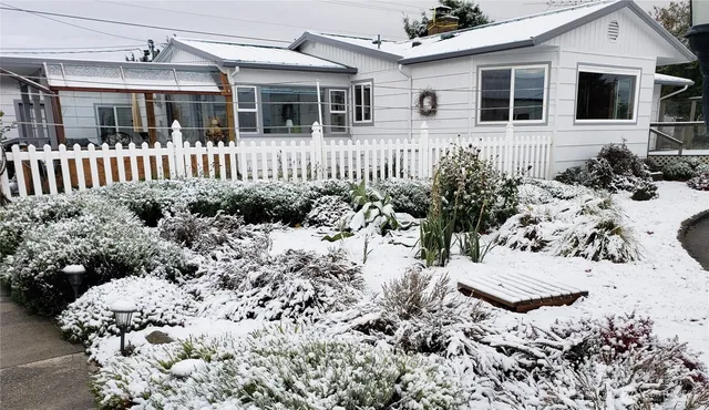 a front view of a house with a yard and potted plants