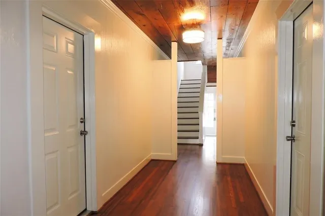 a view of a hallway with wooden floor and staircase