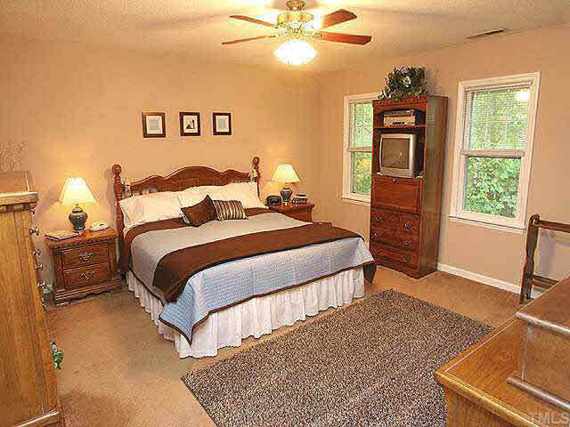 3012 Oxbow Court Raleigh, NC 27613 - Photo 7 of 9 a bedroom with a bed and a chandelier