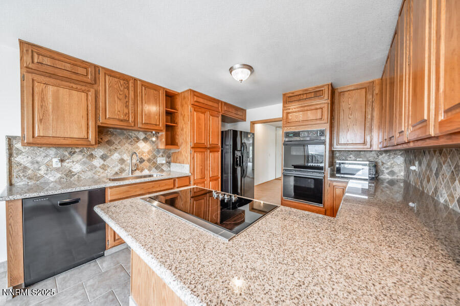 2220 Stone Mountain Circle Reno, NV 89519 - Photo 17 of 58 a kitchen with stainless steel appliances granite countertop a sink stove and granite counter tops