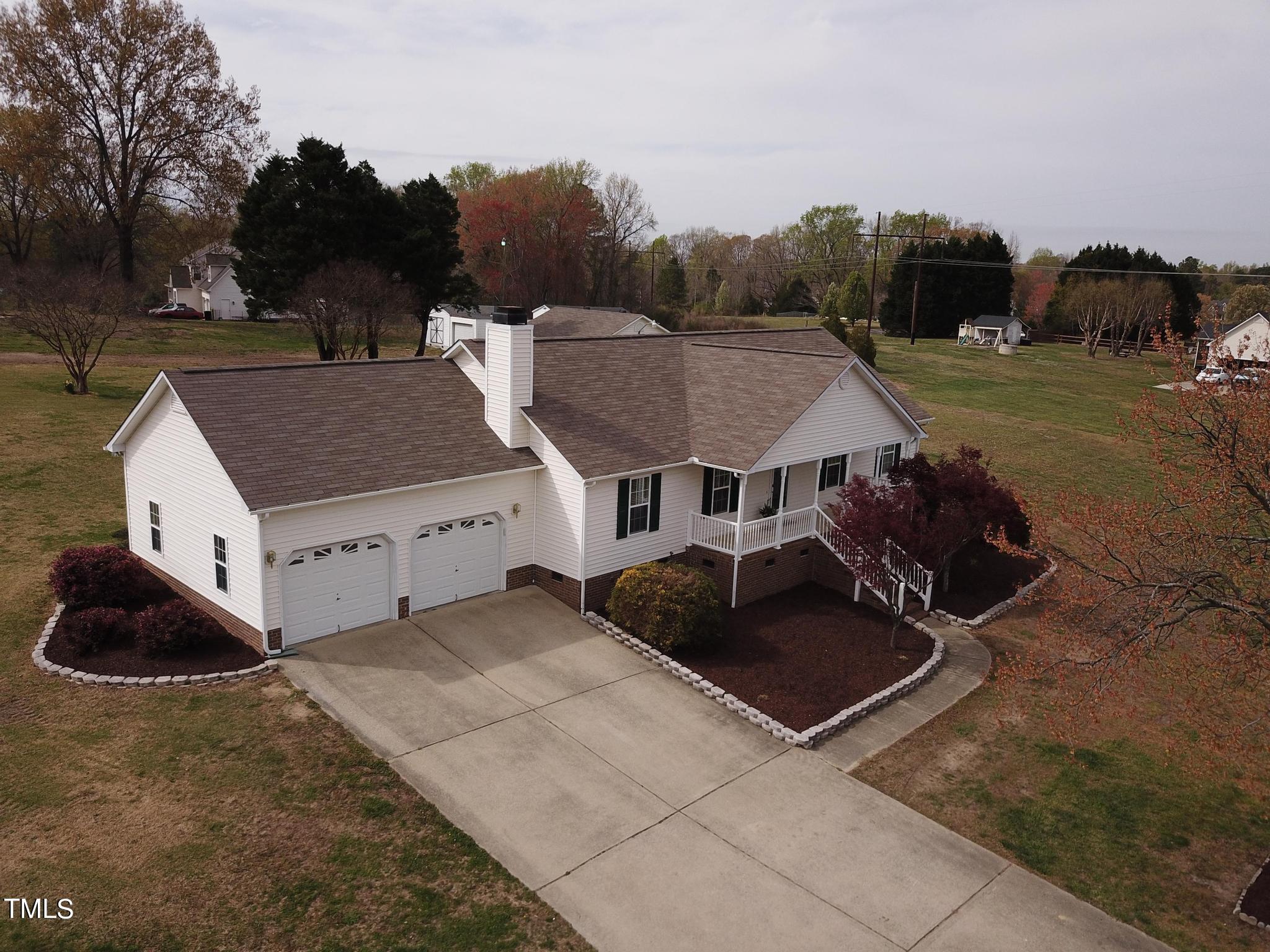 an aerial view of a house with yard and trees around
