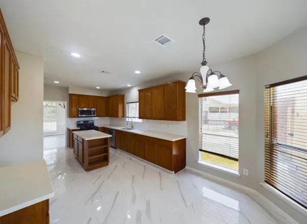 a view of kitchen with granite countertop stainless steel appliances sink and cabinets