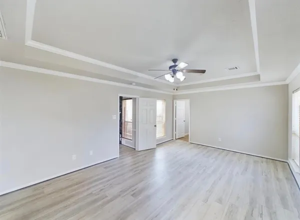 a view of an empty room with wooden floor