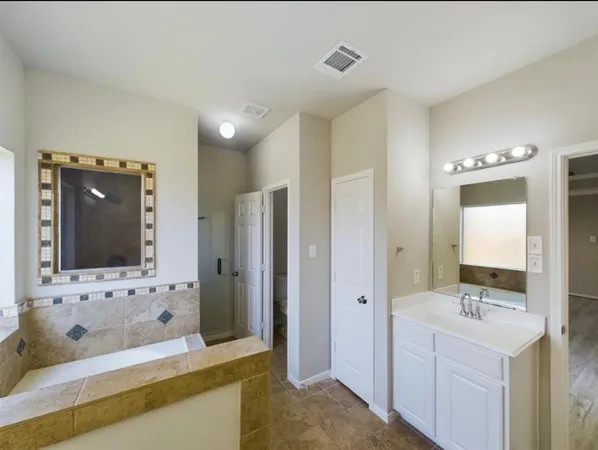 a bathroom with a bathtub sink and mirror