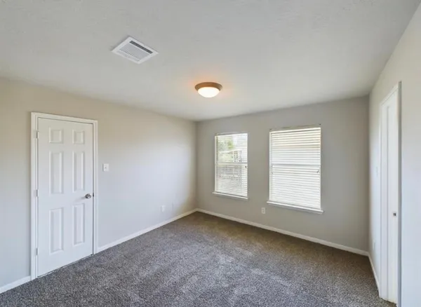 an empty room with windows and closet