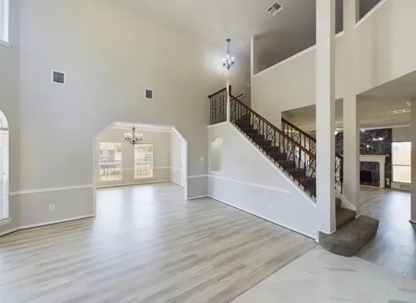 a view of a hallway with wooden floor and staircase