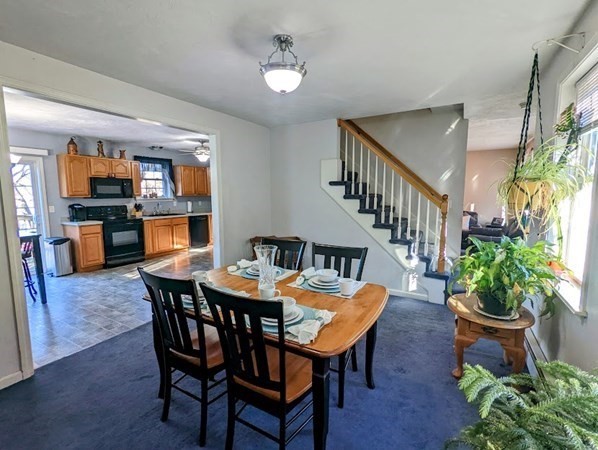 26 El Caney Road Worcester, MA 01603 - Photo 4 of 37 a dining room with furniture potted plants and wooden floor