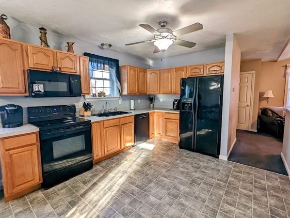 26 El Caney Road Worcester, MA 01603 - Photo 5 of 37 a kitchen with stainless steel appliances granite countertop a refrigerator a stove a sink a dining table and chairs with wooden floor