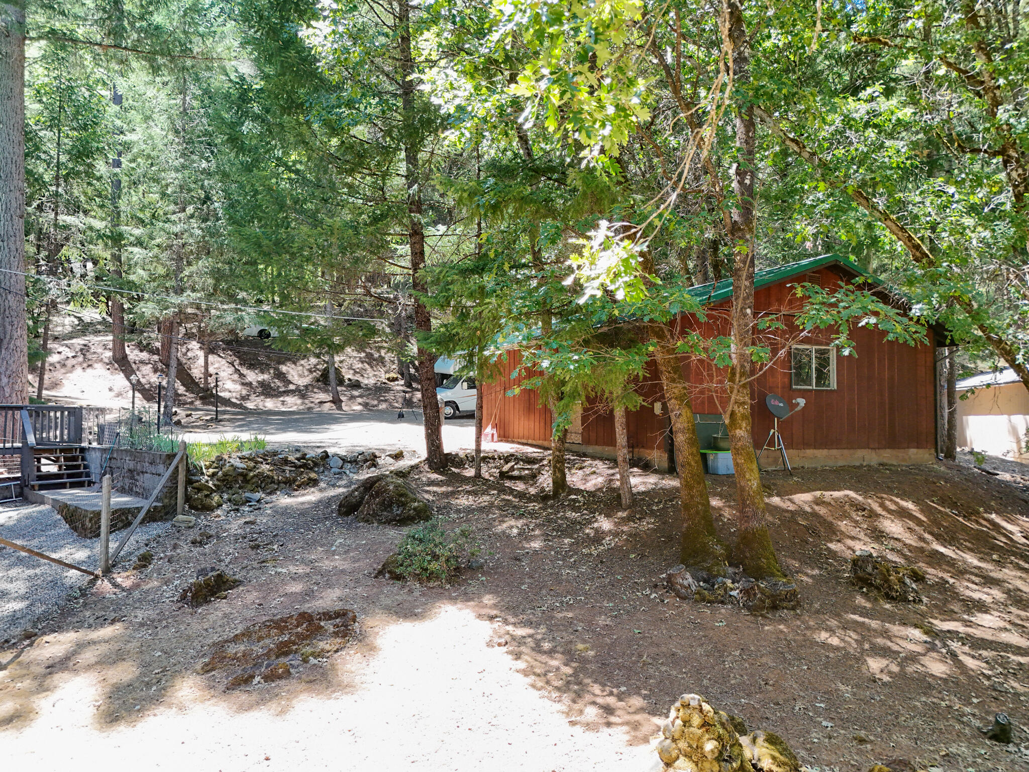 500 Timber Ridge Road Weaverville, CA 96093 - Photo 8 of 61 a backyard of a house with large trees and a wooden fence