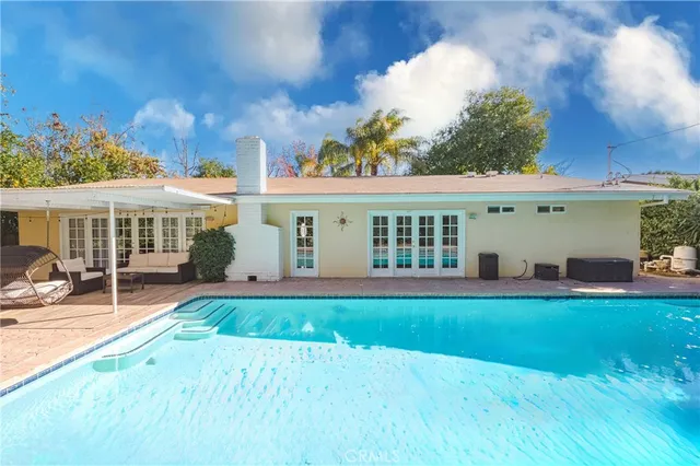 a view of a house with a swimming pool and a yard