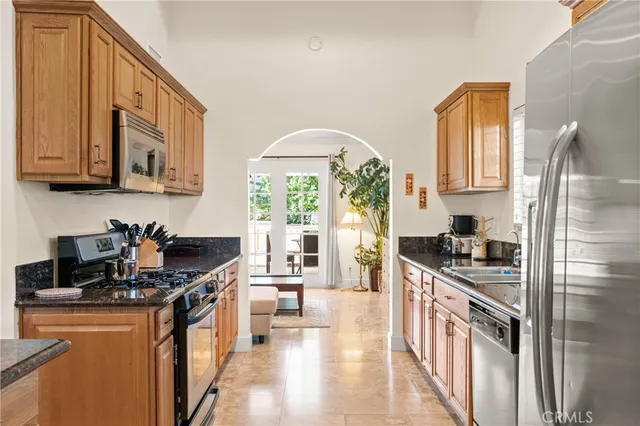 a kitchen with stainless steel appliances granite countertop a stove a sink and a refrigerator