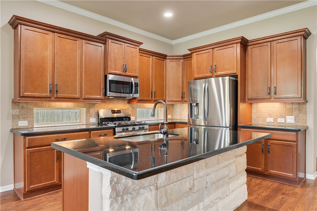 3085 Archer Circle Bryan, TX 77808 - Photo 5 of 31 a kitchen with stainless steel appliances granite countertop a refrigerator a stove a sink and a microwave