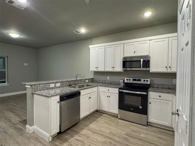 a kitchen with stainless steel appliances granite countertop a stove top oven and sink