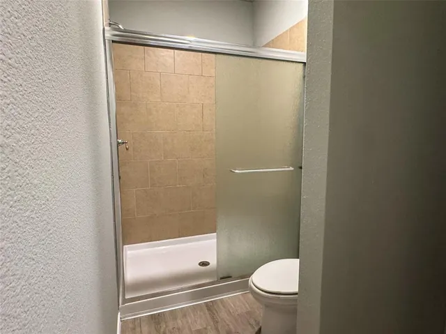 a bathroom with a granite countertop toilet and a shower