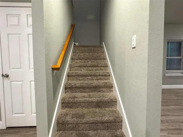 a view of a hallway with wooden floor and entryway