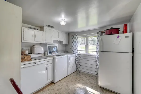 a kitchen with a refrigerator a stove a sink and cabinets