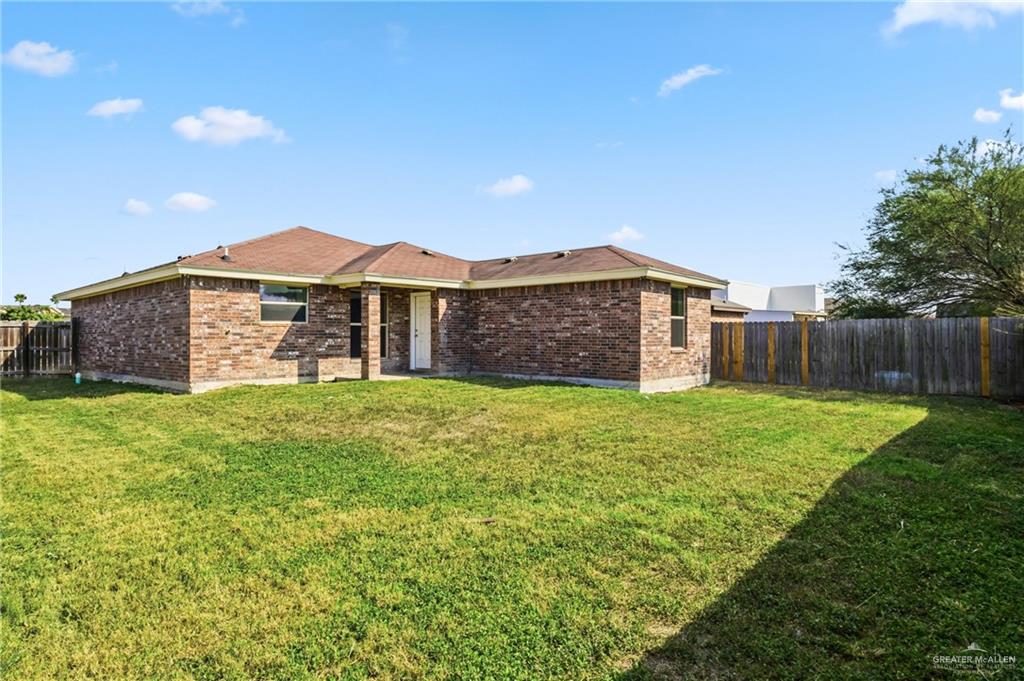 709 Alexandra Avenue Mercedes, TX 78570 - Photo 15 of 16 a view of a yard with a large tree in front of a house