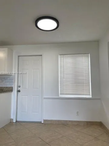 a view of a small space with wooden floor and a window