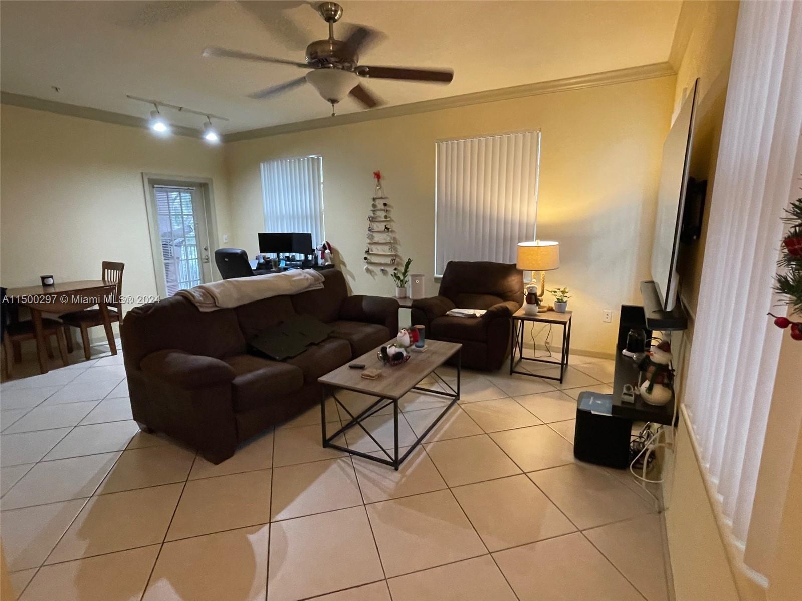 6830 West Sample Road, Unit 6830 Coral Springs, FL 33067 - Photo 1 of 30 a living room with couches and kitchen view with wooden floor