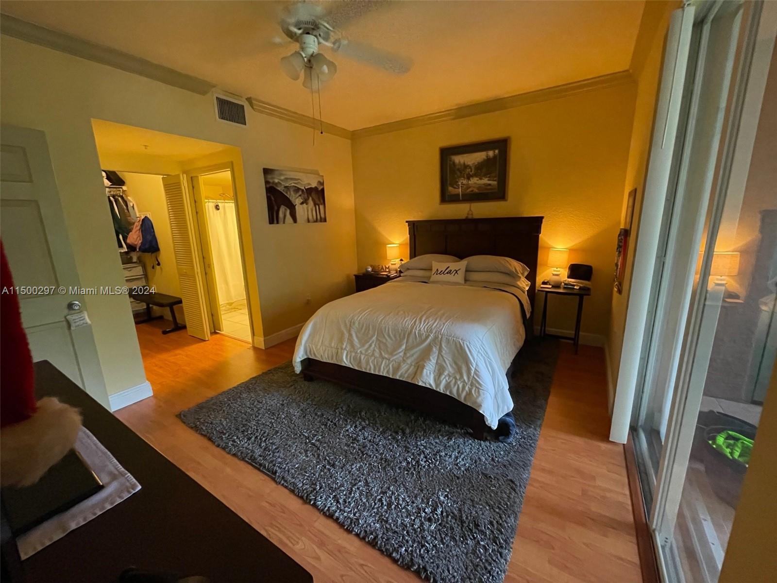 6830 West Sample Road, Unit 6830 Coral Springs, FL 33067 - Photo 12 of 30 a bedroom with a bed and a walk in closet