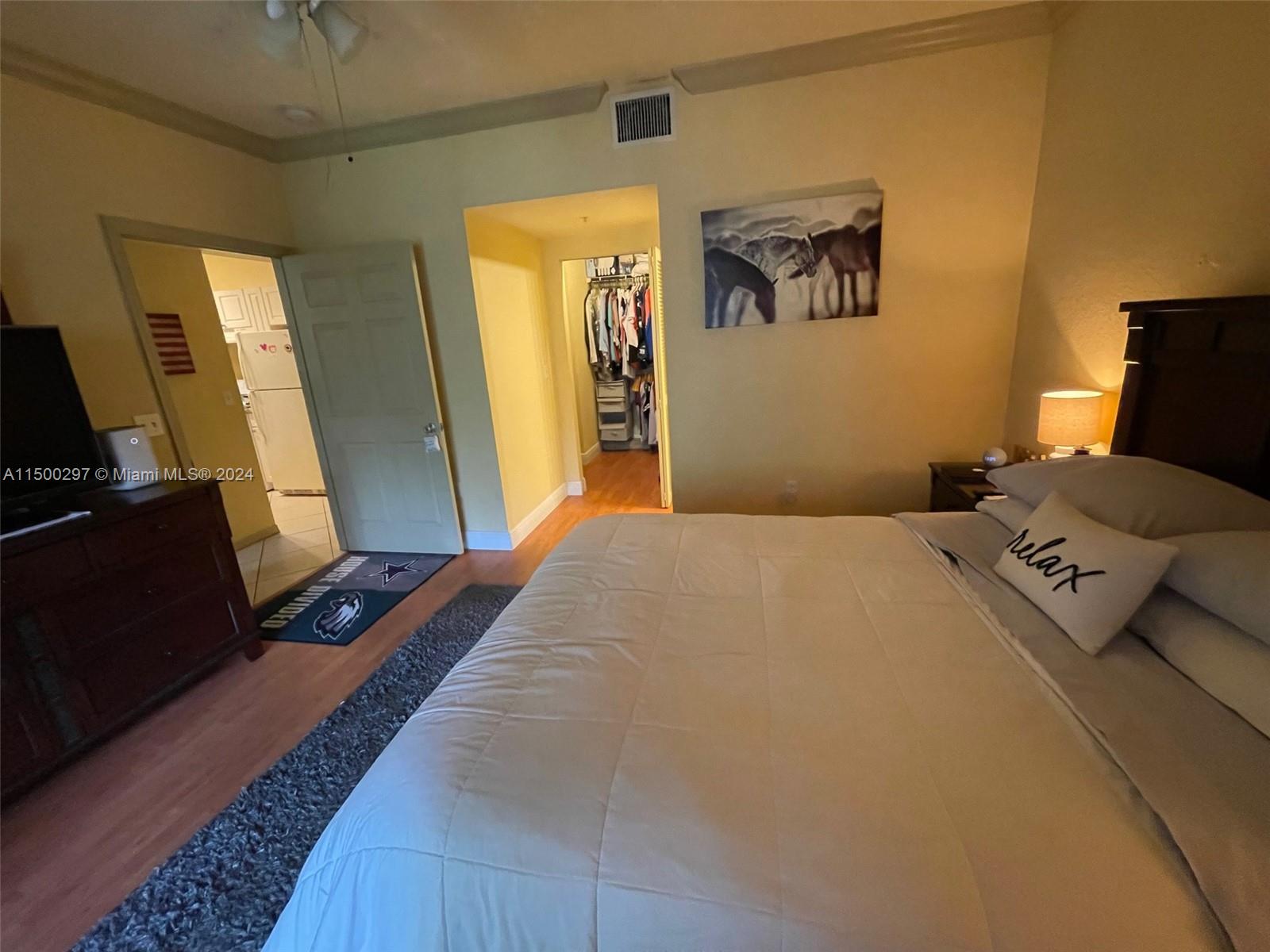 6830 West Sample Road, Unit 6830 Coral Springs, FL 33067 - Photo 13 of 30 a bedroom with a bed and a flat tv screen on a dresser