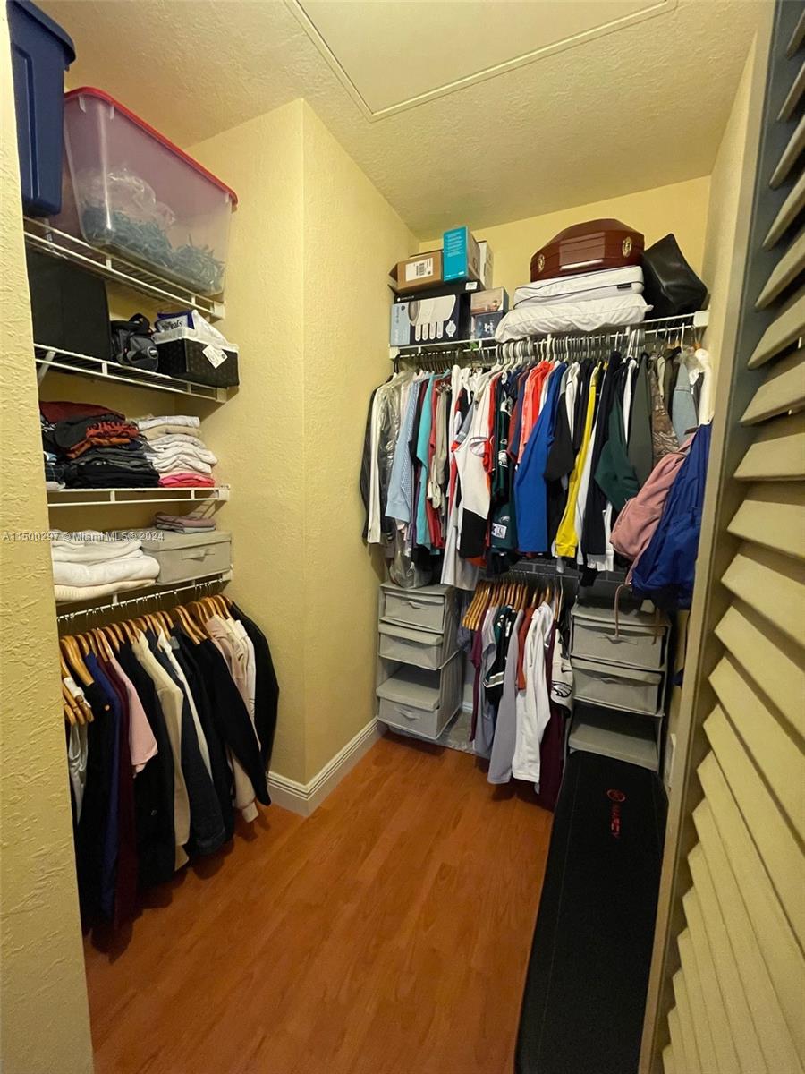 6830 West Sample Road, Unit 6830 Coral Springs, FL 33067 - Photo 19 of 30 a view of walk in closet with clothes and shoes