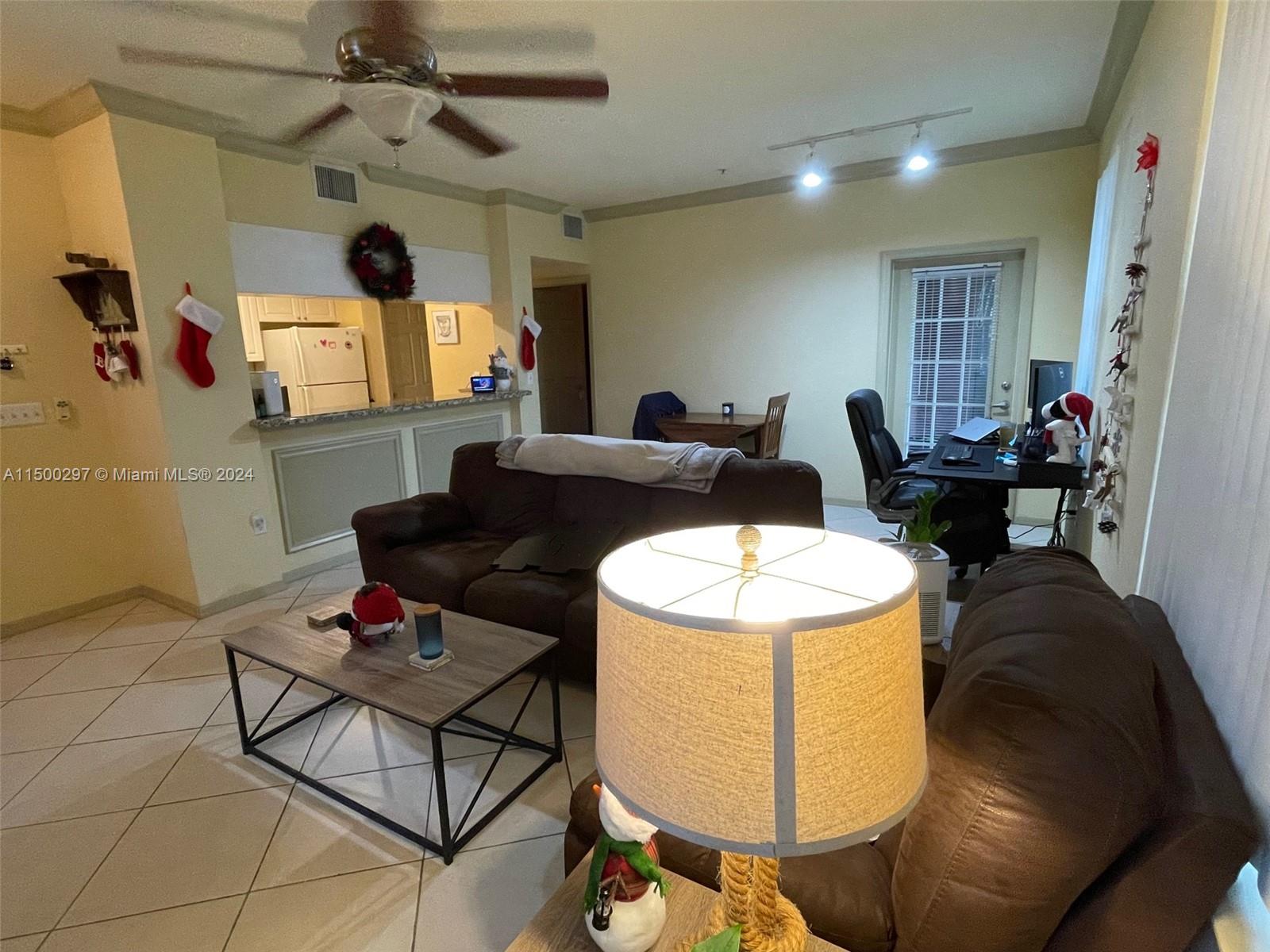 6830 West Sample Road, Unit 6830 Coral Springs, FL 33067 - Photo 2 of 30 a living room with furniture and a chandelier