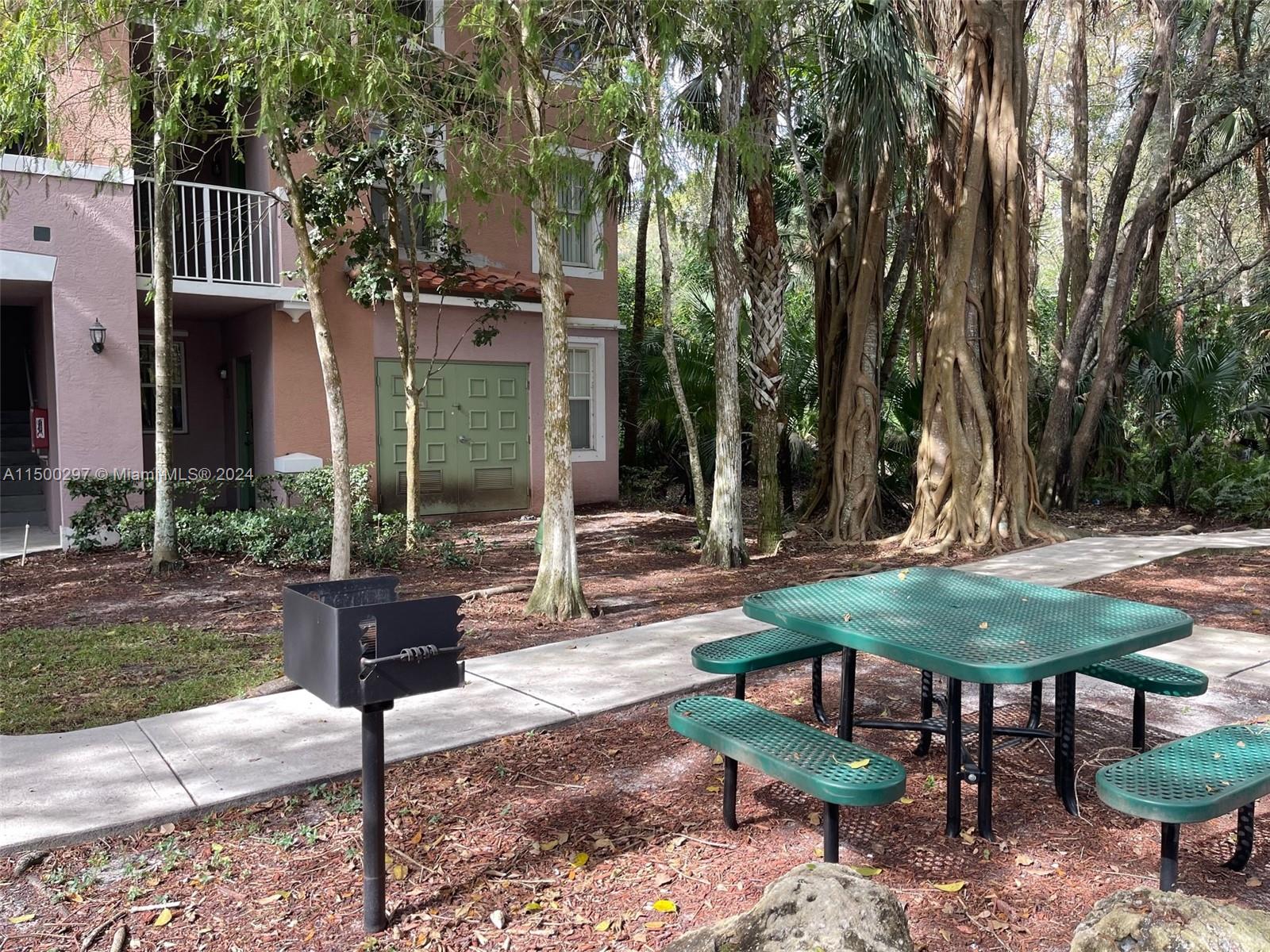 6830 West Sample Road, Unit 6830 Coral Springs, FL 33067 - Photo 23 of 30 a view of a table and chairs in backyard of the house