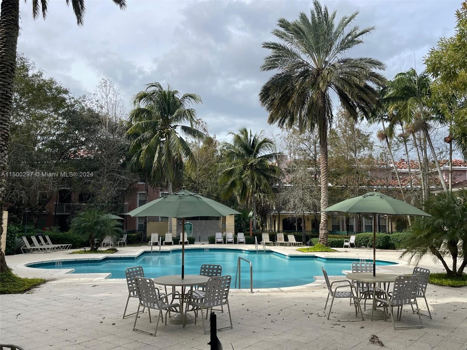 6830 West Sample Road, Unit 6830 Coral Springs, FL 33067 - Photo 26 of 30 a view of a table and chairs under an umbrella in patio