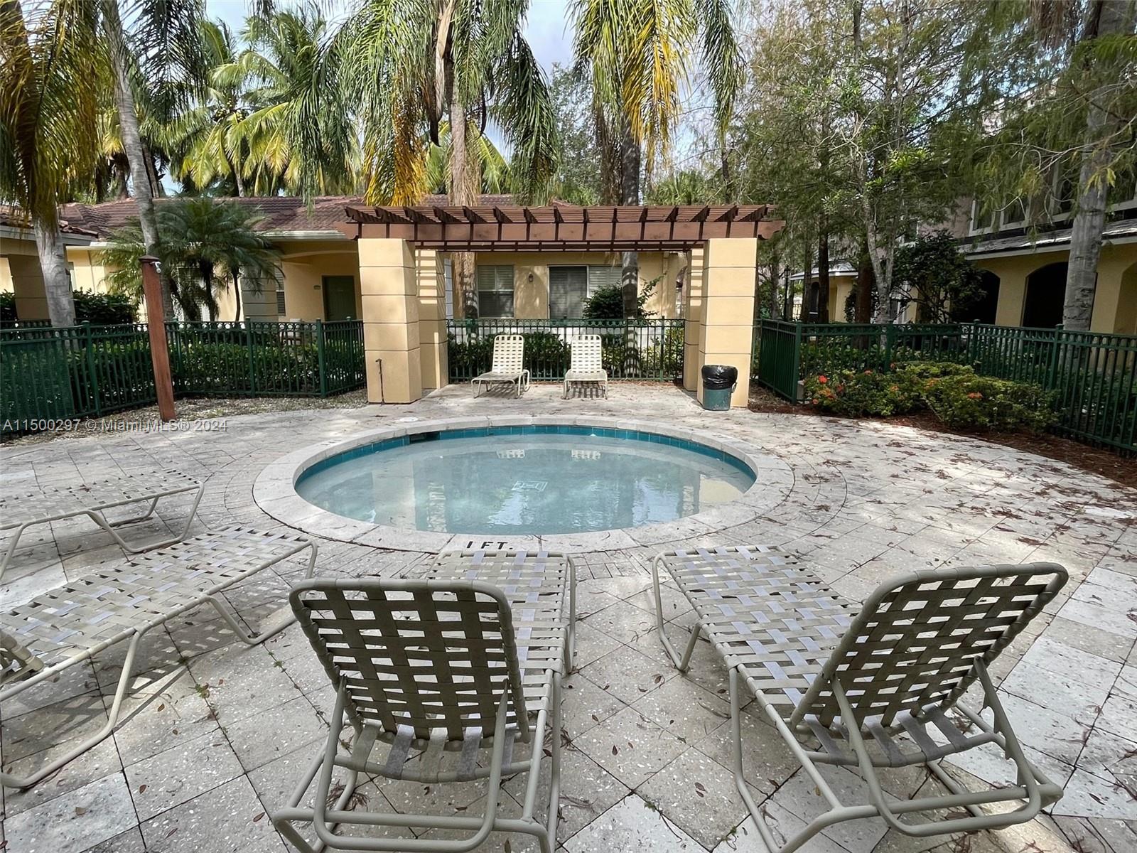 6830 West Sample Road, Unit 6830 Coral Springs, FL 33067 - Photo 27 of 30 a view of a patio with a table and chairs and potted plants