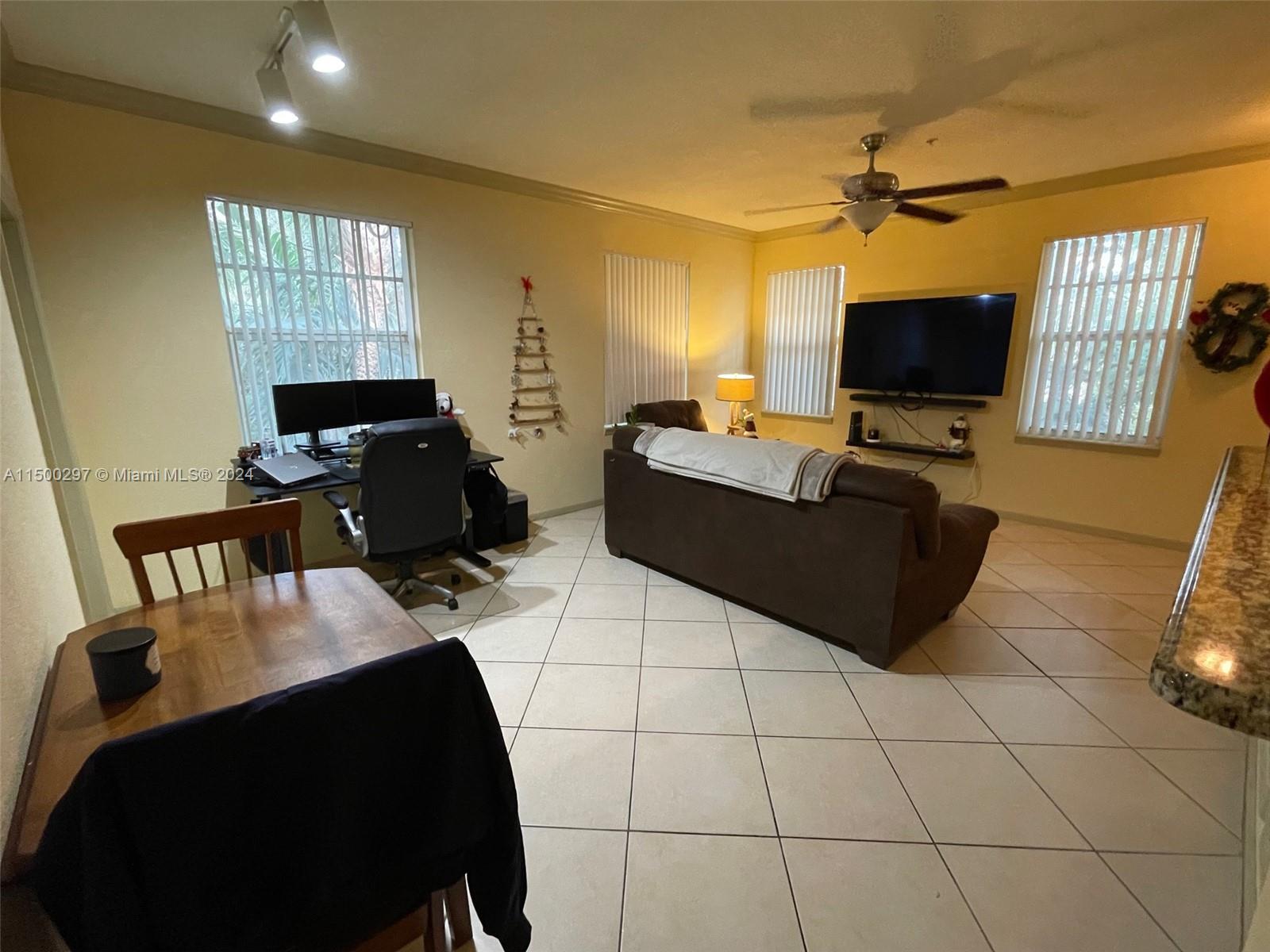 6830 West Sample Road, Unit 6830 Coral Springs, FL 33067 - Photo 3 of 30 a living room with furniture and a flat screen tv
