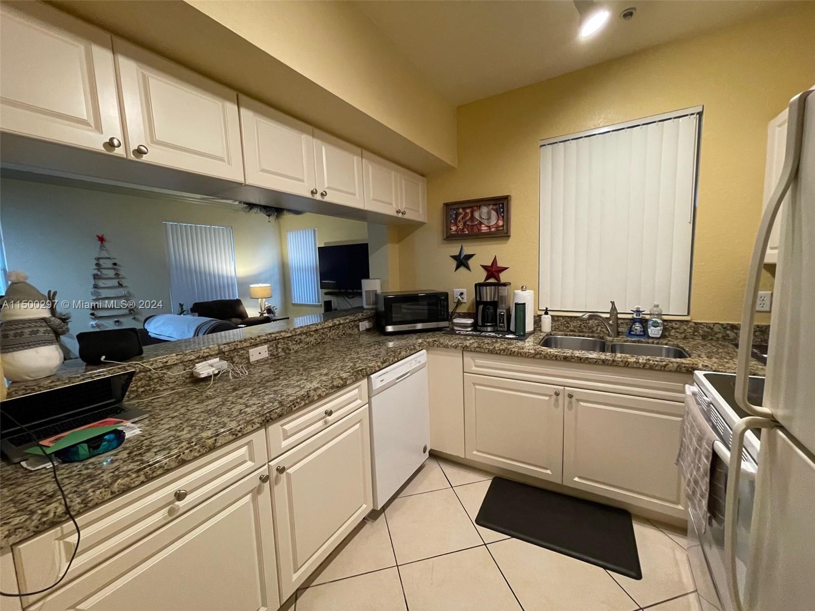 6830 West Sample Road, Unit 6830 Coral Springs, FL 33067 - Photo 4 of 30 a kitchen with stainless steel appliances granite countertop a sink and cabinets