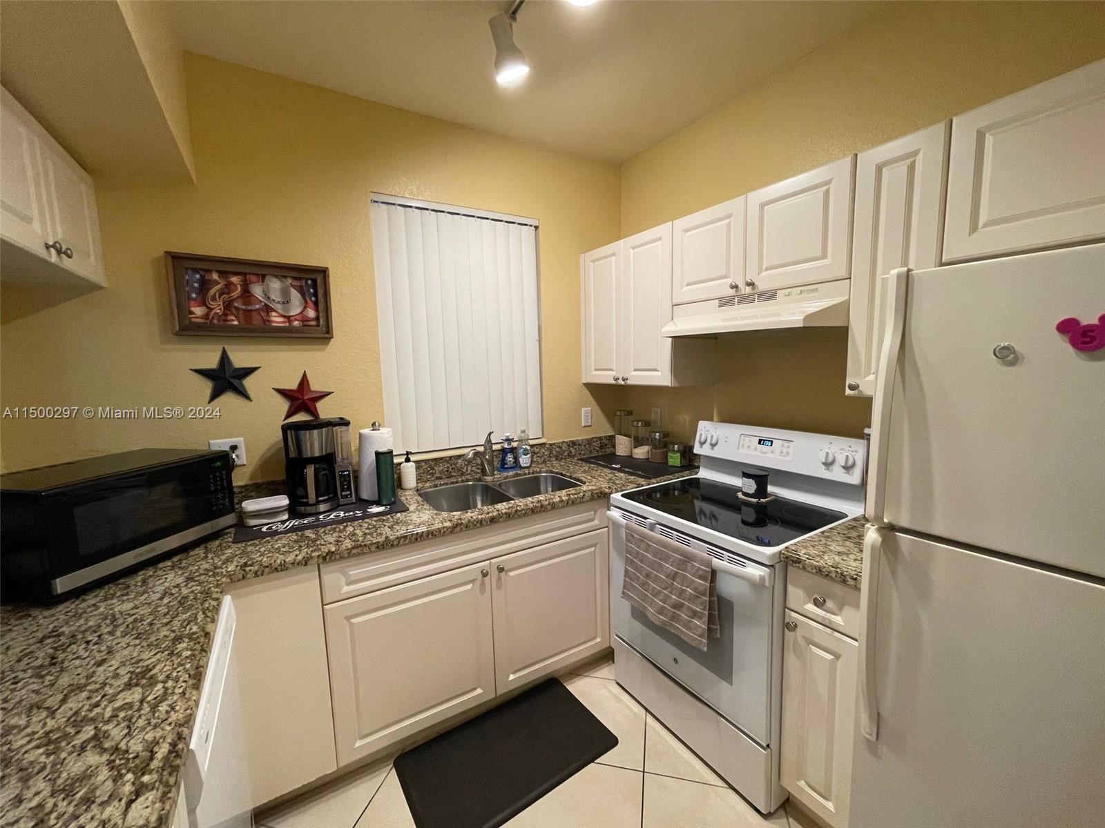 6830 West Sample Road, Unit 6830 Coral Springs, FL 33067 - Photo 6 of 30 a kitchen with stainless steel appliances a sink stove and refrigerator
