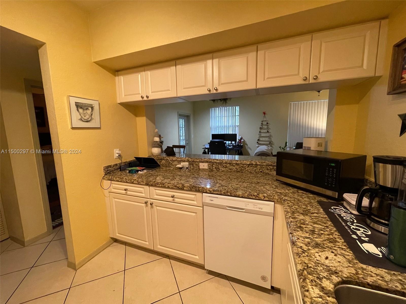6830 West Sample Road, Unit 6830 Coral Springs, FL 33067 - Photo 7 of 30 a kitchen with stainless steel appliances granite countertop a sink and cabinets