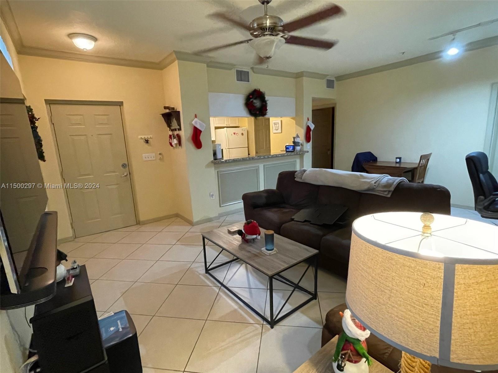 6830 West Sample Road, Unit 6830 Coral Springs, FL 33067 - Photo 9 of 30 a living room with furniture and a flat screen tv